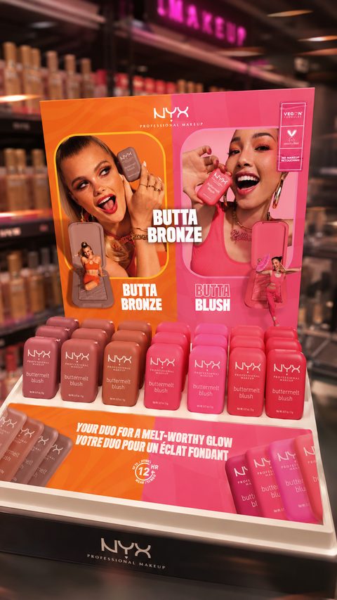 Présentoir NYX Professional Makeup rose et orange dans un rayon de magasin.